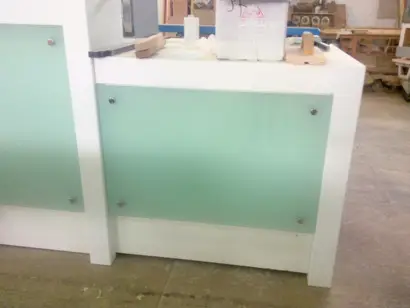 dettaglio banco cassa in corian e vetro bianco latte