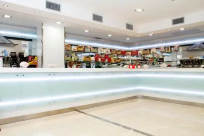 Bancone bar su misura per ospedale in Corian bianco con pannelli in vetro bianco latte retroilluminati