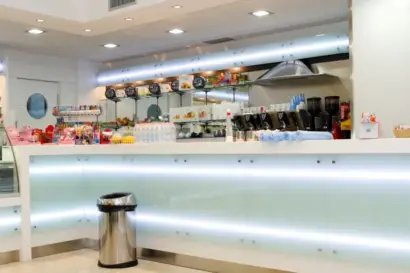 Bancone bar su misura per ospedale in Corian bianco con pannelli in vetro bianco latte retroilluminati