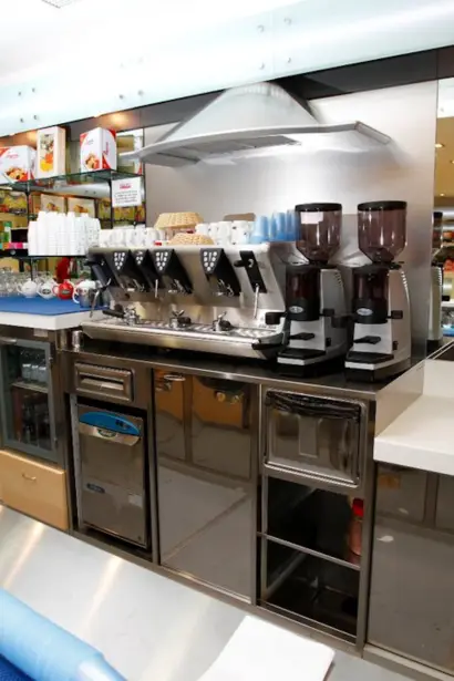 Postazione caffè in acciaio inox con macchina espresso e macinadosatori nel bar dell'ospedale